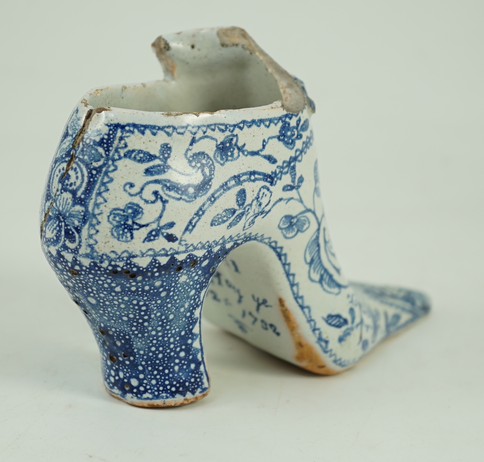 A documentary English delftware blue and white model of a shoe, dated 1732, 16cm long, damage